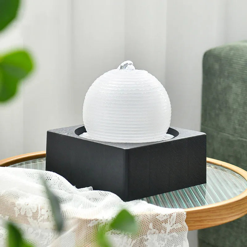 Transform your space into a calm oasis with the LED-Lit Indoor Tabletop Ball Fountain. Featuring an illuminated Stonewall, river rocks, and soothing water sounds, it's perfect for relaxation and adding moisture to the air.