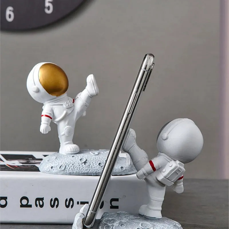 Add whimsy to your desk with the Nordic Style Astronaut Mobile Phone Stand Holder. Made from durable resin, it combines playful design with practical phone support.