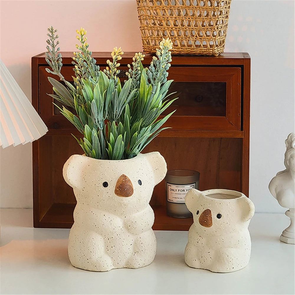 Discover our adorable Small Ceramic Koala Vase, perfect for adding whimsy to any space. Available in two sizes, it's ideal for displaying flowers or as a standalone decor piece.