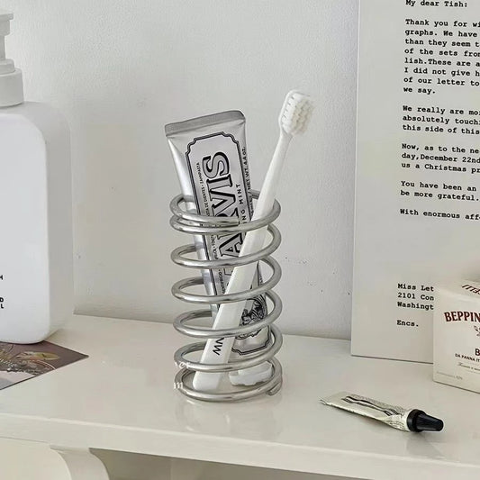 Keep your bathroom organized with this minimalist stainless steel toothbrush stand. Durable, hygienic, and versatile, it accommodates toothbrushes, electric heads, and toothpaste tubes.